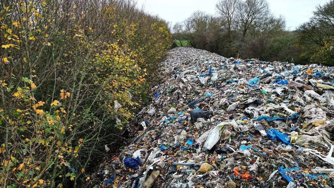Fly-tipped waste dumped along a rural lane before clearance