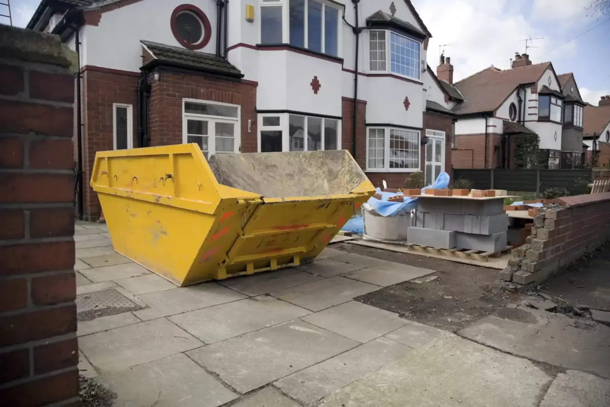 Yellow skip on a residential driveway in the UK